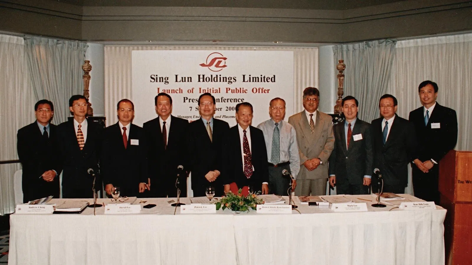 2000年，星纶控股上市发布会上，李氏三代同框：公司创办人李子衡（左六）、长子李国钧是公司董事（左四）、三子李国基担任董事长（左五）以及第三代李坚辉（右一）。（受访者提供）