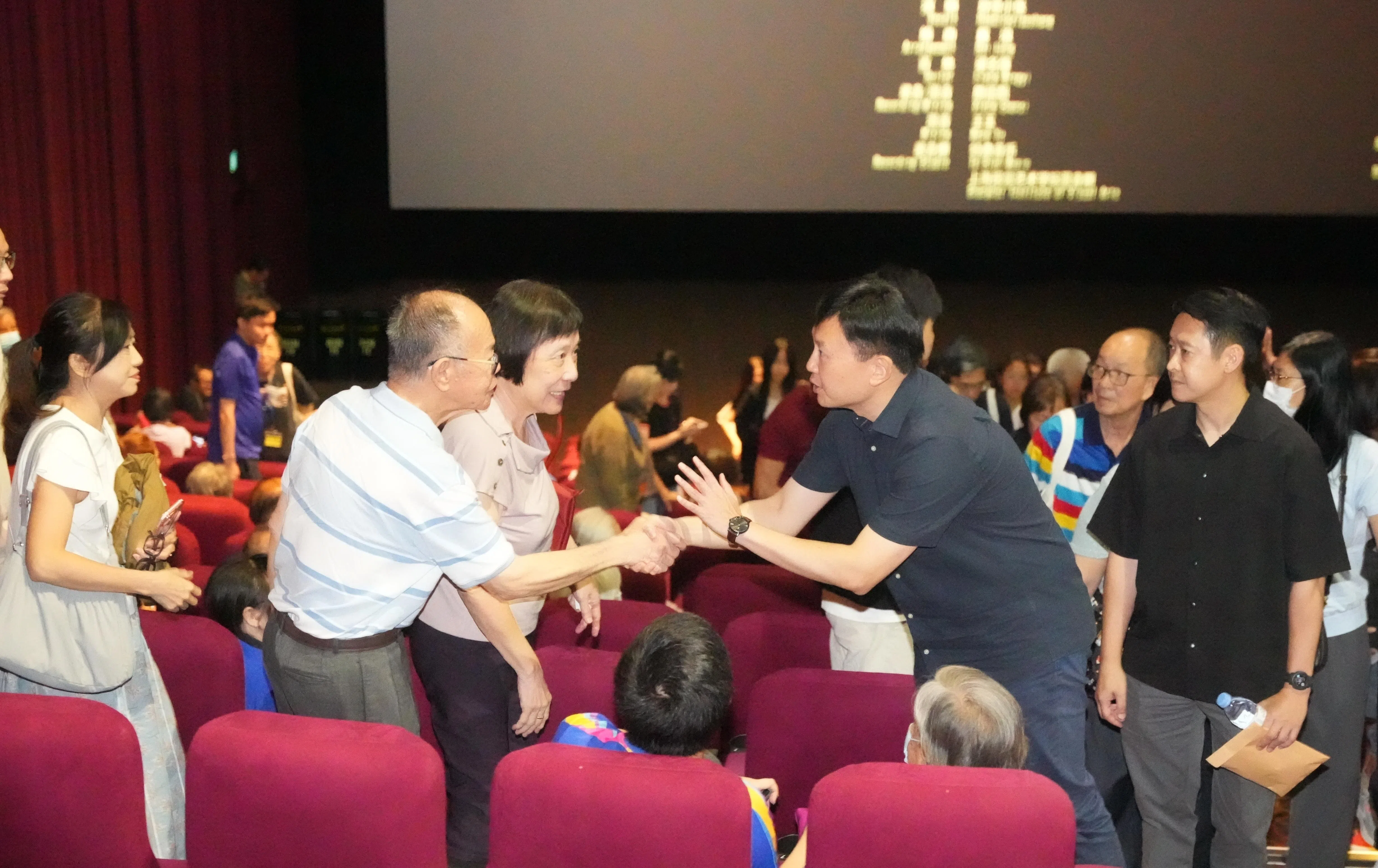 国家发展部长徐芳达7月4日在电影《给阿嬷的情书》潮语原音版放映会结束后，与现场观众握手致意。（谢智扬摄）