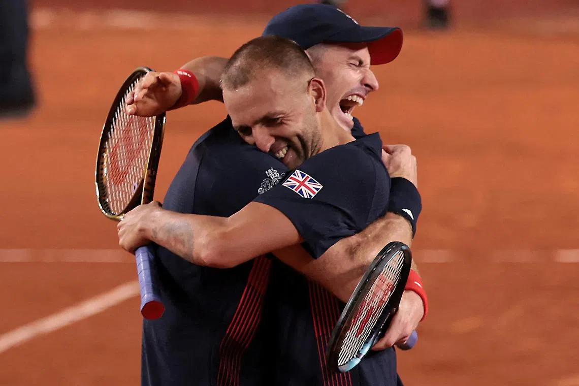 默里（左）经历艰难激战获胜后，和搭档埃文斯紧紧拥抱。（路透社）