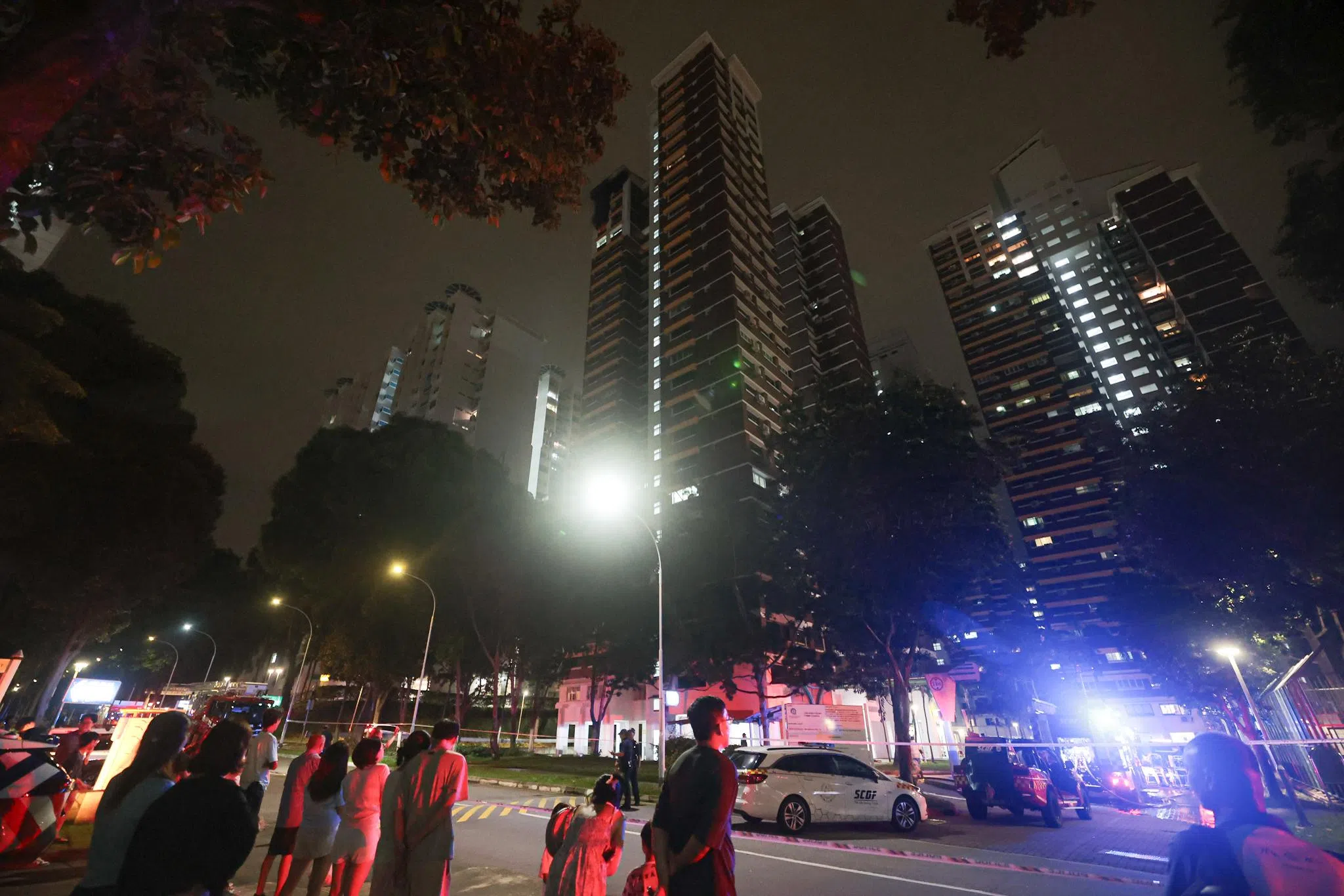 新加坡警察部队到场后拉起封锁线，居民则到附近的足球场等待。火势在晚上8时55分左右受到控制。（李冠卫摄）