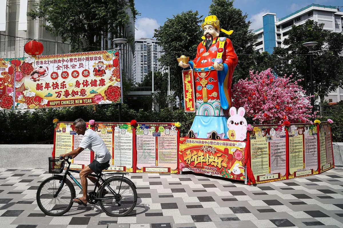 在勿洛北第216座熟食中心与巴刹附近，高约四米的财神爷塑像和新春装饰使邻里年味渐浓。（李健玮摄）