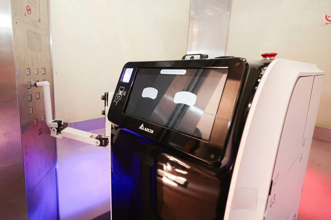 名为“AIDEN”的机器人附带手臂，能够自行按下电梯按钮，前往指定的组屋楼层。（李冠卫摄）