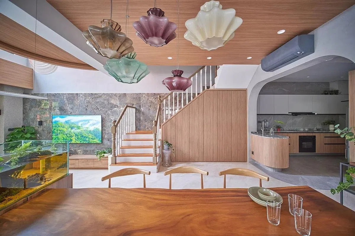 客厅与饭厅之间的鱼缸是屋子的设计焦点，用餐区吹制玻璃灯饰有如花朵，8英尺实木餐桌增添气派。（萧文杰提供图片）