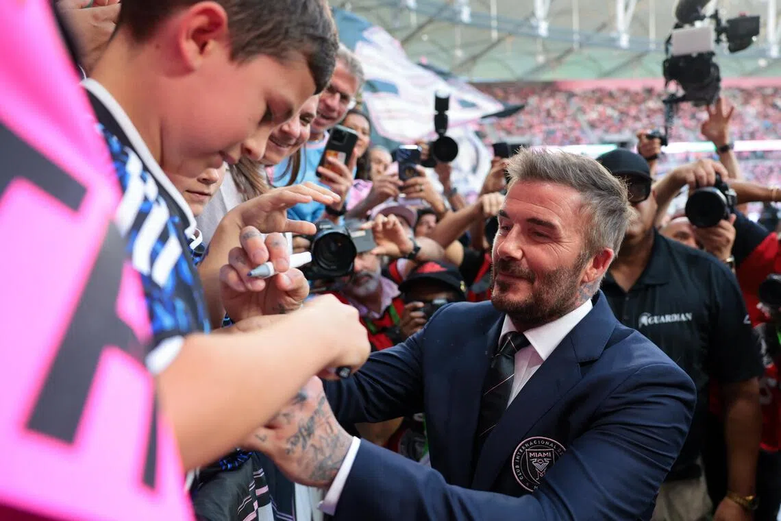 贝克汉姆（右）对这座新球场布局已久，图为他在比赛前为来到现场的球迷签名。（路透社）