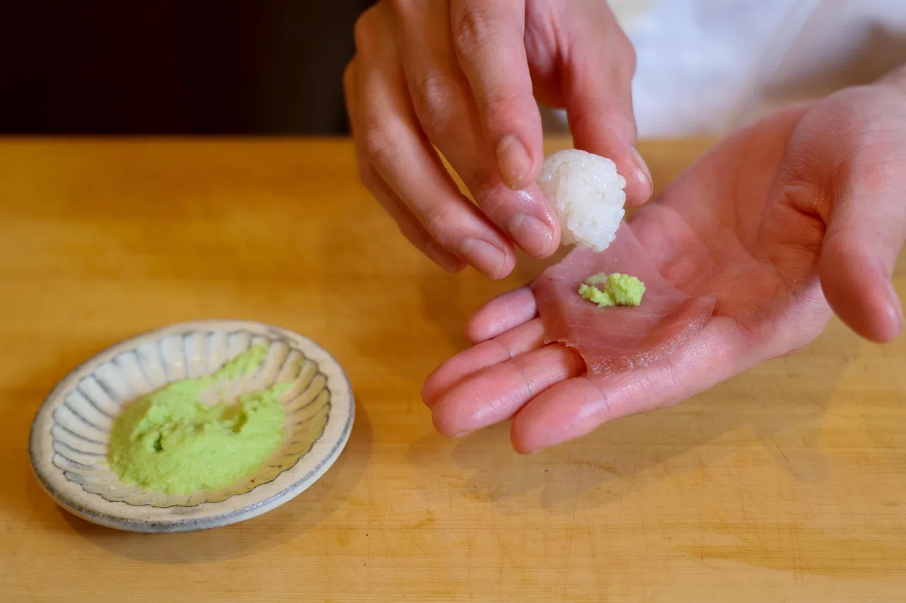 厨师在捏制寿司时，一般会预先在刺身和米饭之间放好适量的山葵。（龙国雄摄）