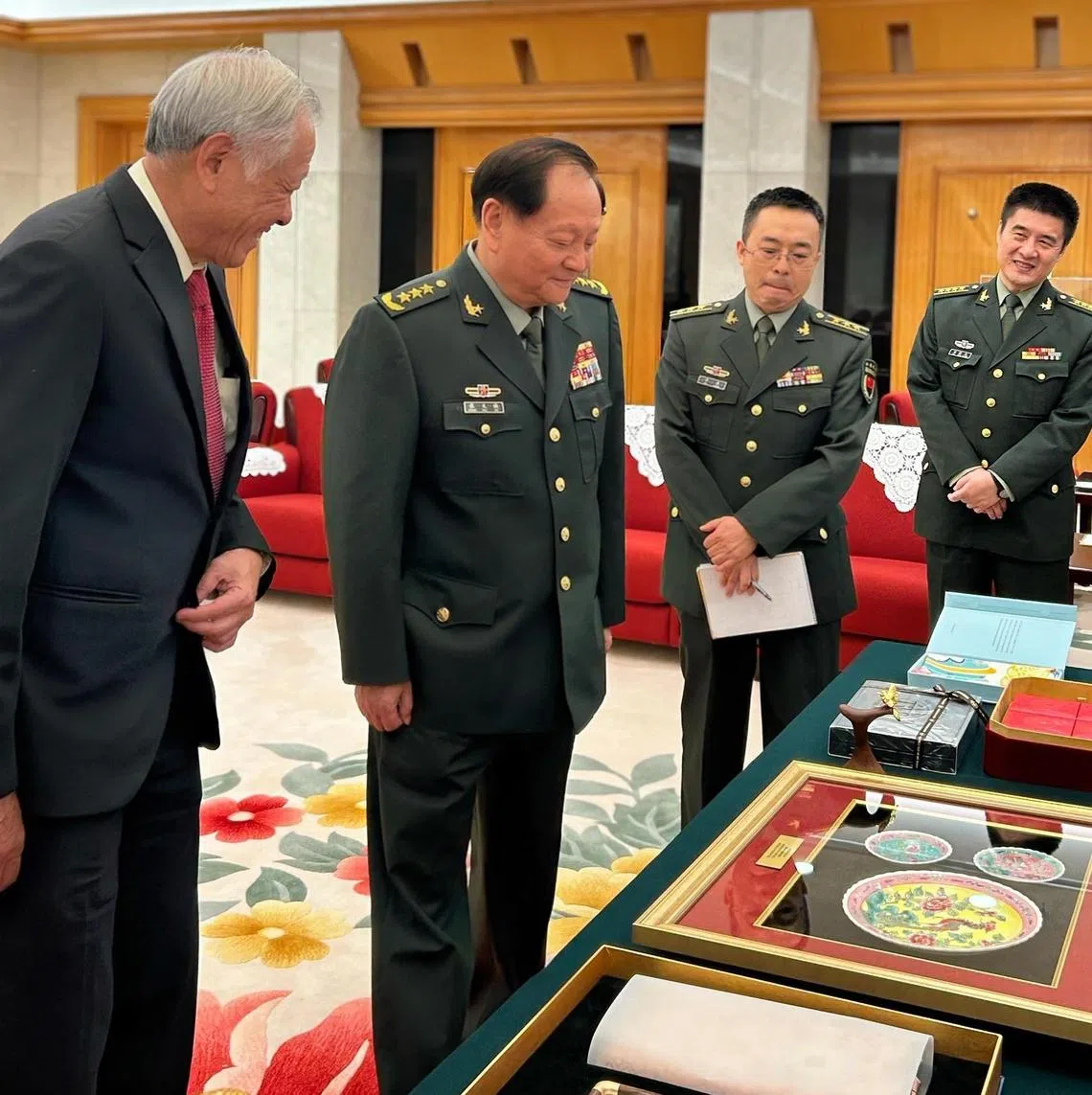 我国国防部长黄永宏医生（左）回赠中共中央军委副主席张又侠印有凤凰图案的娘惹风格瓷盘。（取自黄永宏脸书）