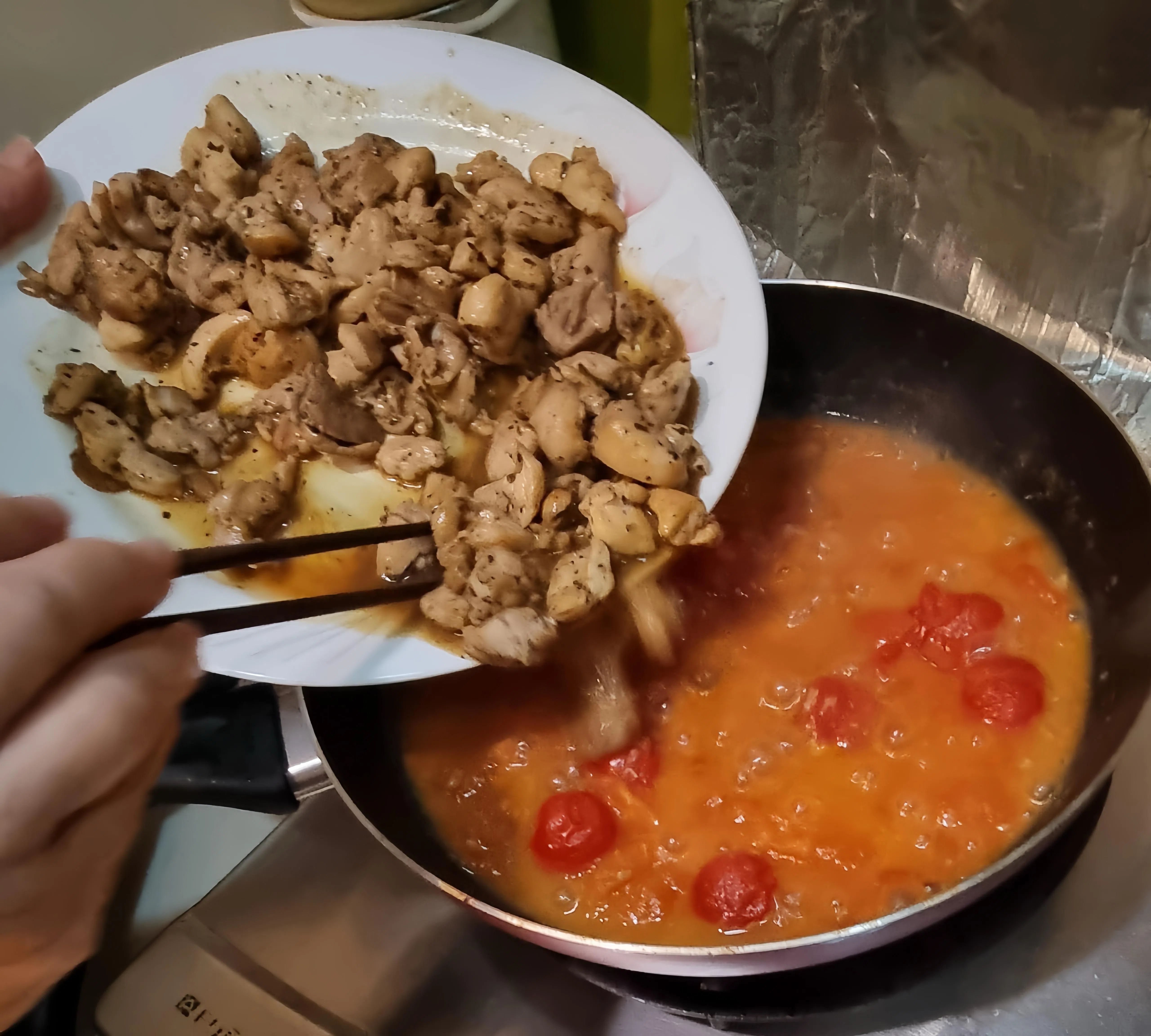 在锅中加入炒熟的鸡肉，接着轻轻拌匀，盖上锅盖煮2分钟即可上桌。（受访者提供）