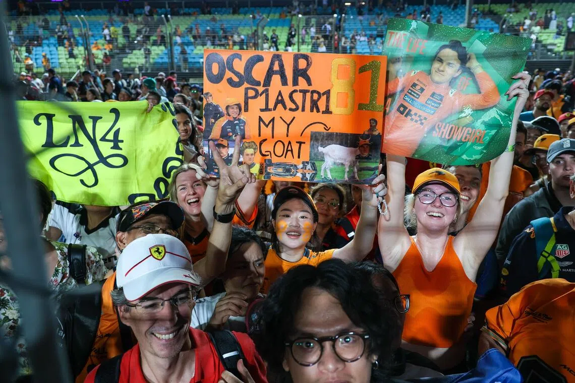 现场众多身穿橙色队服的迈凯伦车迷也涌上了赛道，一起见证迈凯伦加冕瞬间。（张俊杰摄）