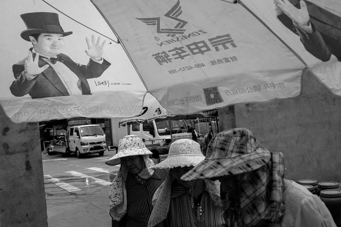 暑气逼人，人人戴上帽子，遮挡阳光，寻找片刻的阴凉。（林明顺摄）