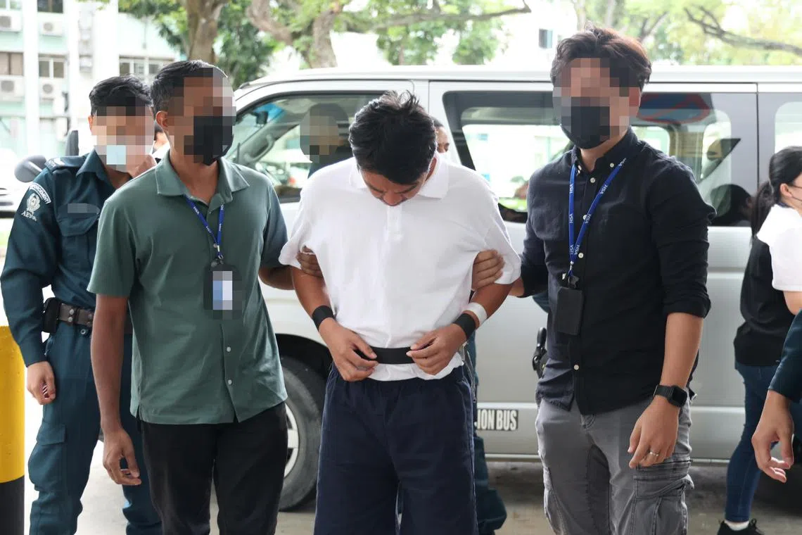 被告穿着白衣短裤和一双透明人字拖鞋，手脚被绑。从小型货车下车后，被告全程低头神情凝重，在卫科局人员的押送下，乘坐电梯到组屋11楼协助调查。（郑一鸣摄）