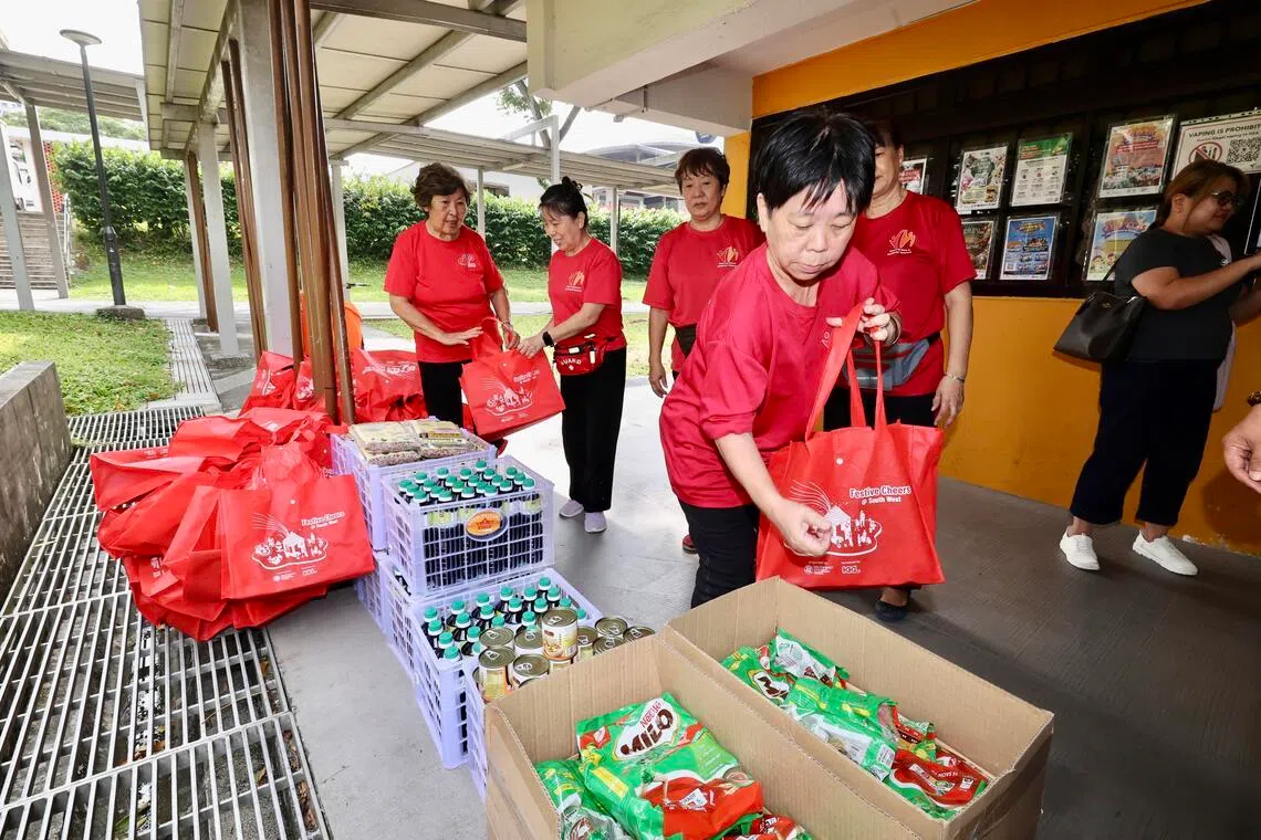 黄宝珠（前）每周都会到文礼住家附近的居民联系网中心报到，完成不同邻里任务，包括为有需要居民打包礼品包。（周国威摄）