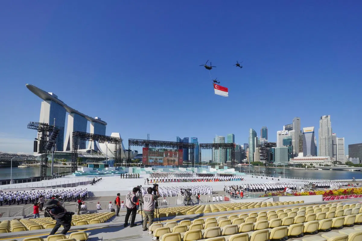 国旗致敬环节里挂在直升机上的国旗重达140公斤，是一个半篮球场的面积。如果25人同时卷起它，也须花上20分钟。（林泽锐摄）