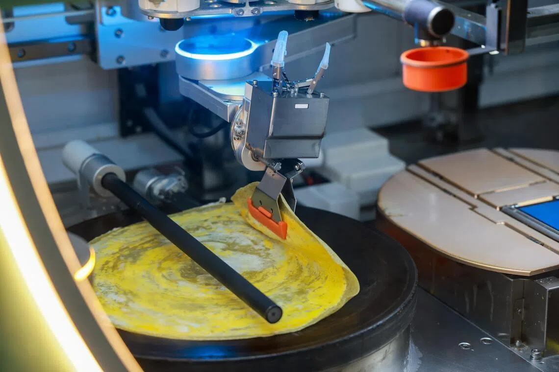 本地也引进一款全自动的“口耐煎饼馃子机器人”，客人在贩卖机点餐后，由机器人现场利用新鲜食材如绿豆粉、水等来和面，加上鸡蛋和酱料做烙饼，三分钟完成一份煎饼馃子。（陈斌勤摄）