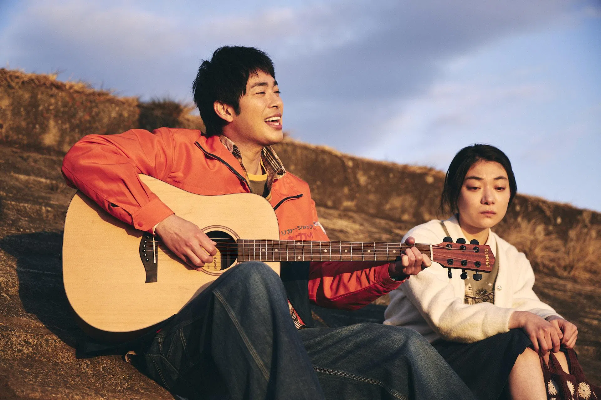 冈部（左）为克子弹吉他吟唱，两人在剧中的爱情纯真动人。（Disney+提供）