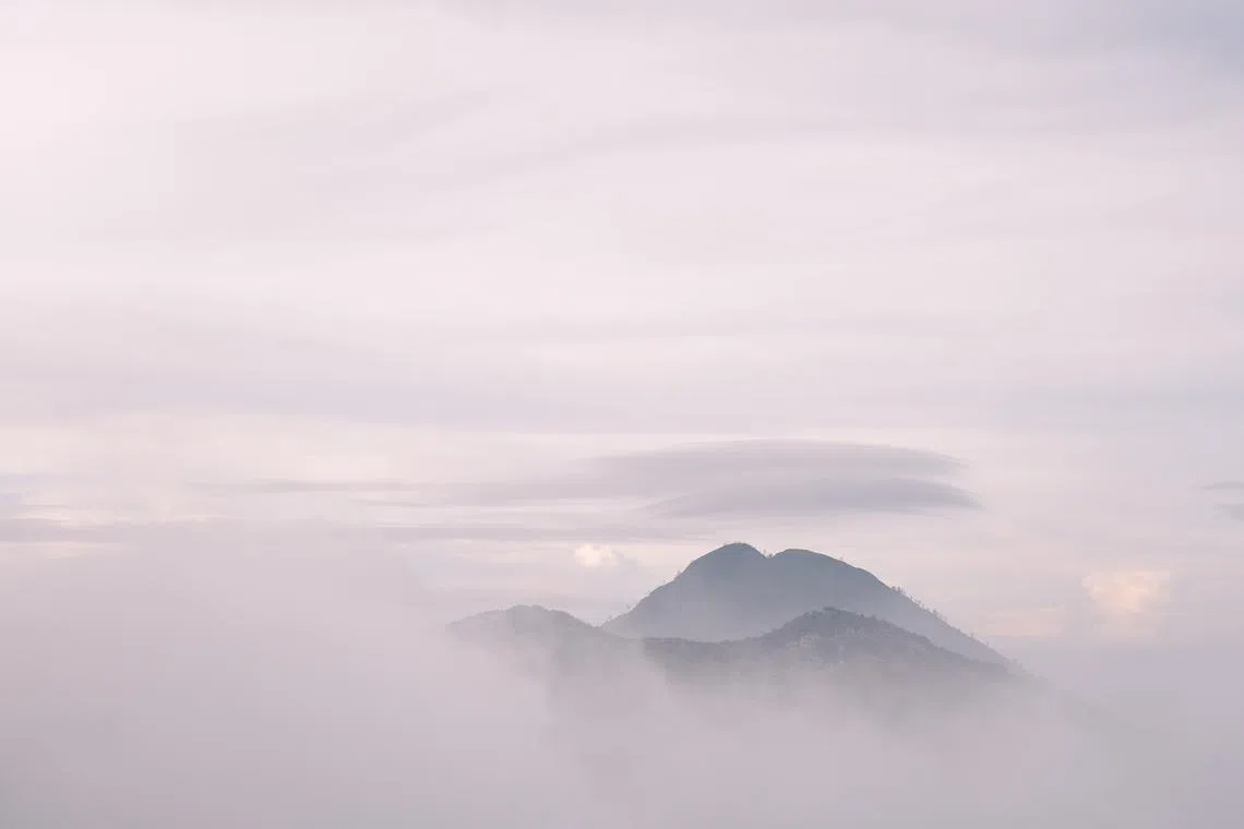 硫磺烟雾笼罩着附近的山峰。（钟俊鸿摄）