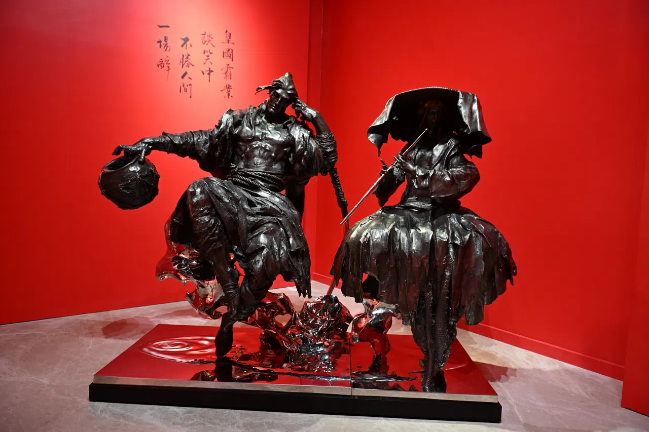 展览中的令狐冲和任盈盈雕塑，两人是金庸小说《笑傲江湖》的主角，小说最早在本地的《新明日报》连载。（新加坡中国文化中心提供）
