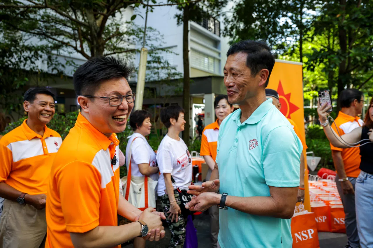 行动党团队在海军部地铁站附近走访时，碰上同样在活动的国民团结党。王乙康和团结党秘书长黄俊宏问好。（叶振忠摄）