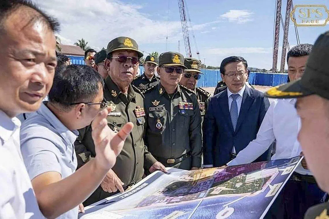 柬埔寨国防部长迪世哈12月7日在脸书上载照片显示，柬埔寨前国防部长迪班（左三）、迪世哈（中）及中国驻柬埔寨大使王文天（右三）在首次到访云壤海军基地的中国军舰上看地图。（法新社）