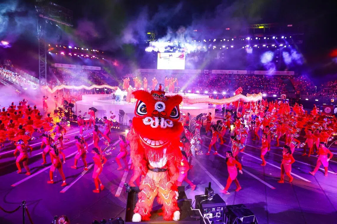 第二幕以农历新年为主题的表演中，舞狮舞龙、踩高跷，以及穿着红包、橘子、鱼等吉祥服饰的表演者卖力律动。（林明顺摄）