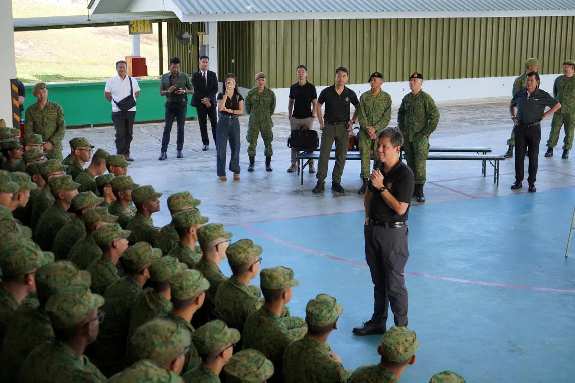公共服务统筹部长兼国防部长陈振声（持麦克风者），星期六上午在文莱淡布隆同在当地受训的军人交流。（国防部提供）