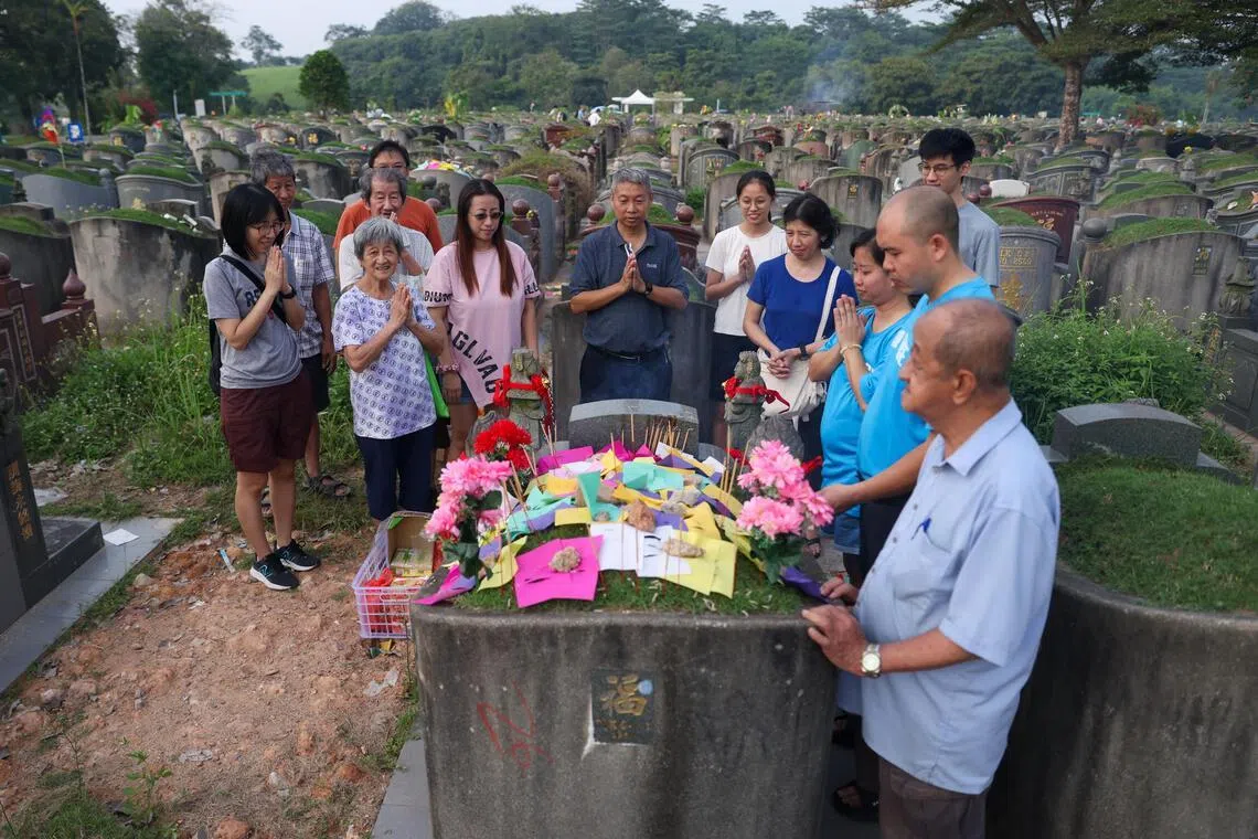 朱氏家族共13人早晨扫墓，在清明正日前一天团聚缅怀往生者，孙辈自制祭品寄托对祖母的思念。（白艳琳摄）