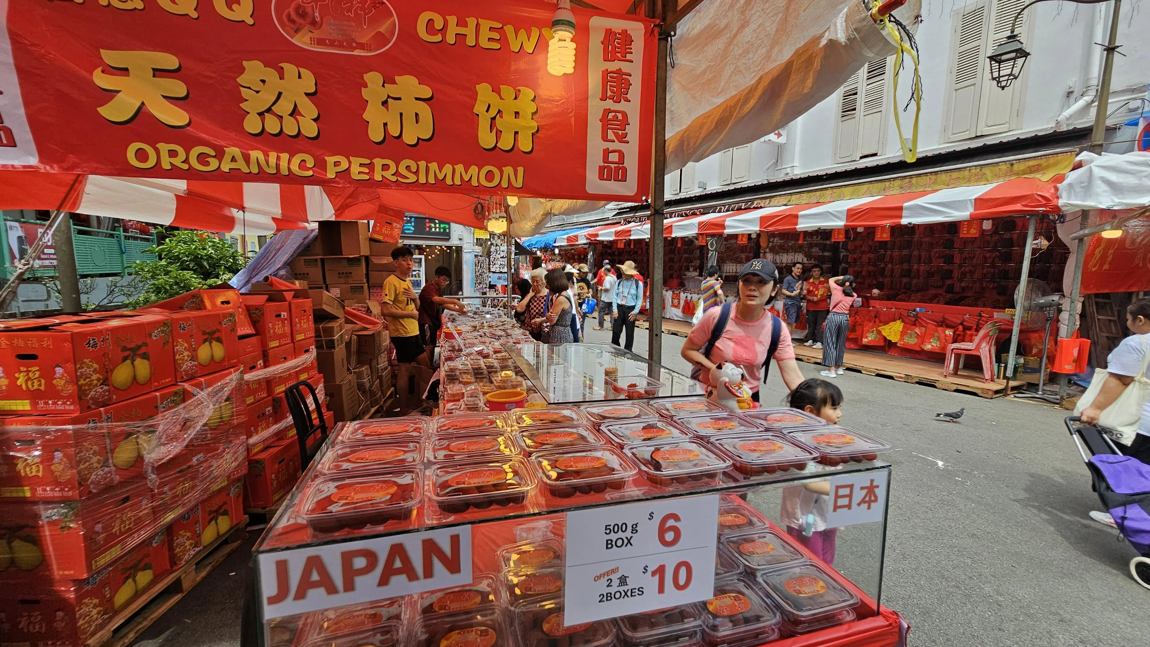 林贵财今年成功以1万3000元标到“旺摊”，售卖从日本进口的有机柿饼、蜜饯与柚子。（梁麒麟摄）