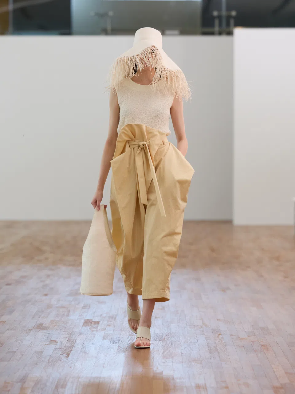 传统编织这个文化基因体现在此系列，如这顶刻意不收边，草绳“杂生”的度假草帽，搭配现代风渔夫裤。（品牌提供）