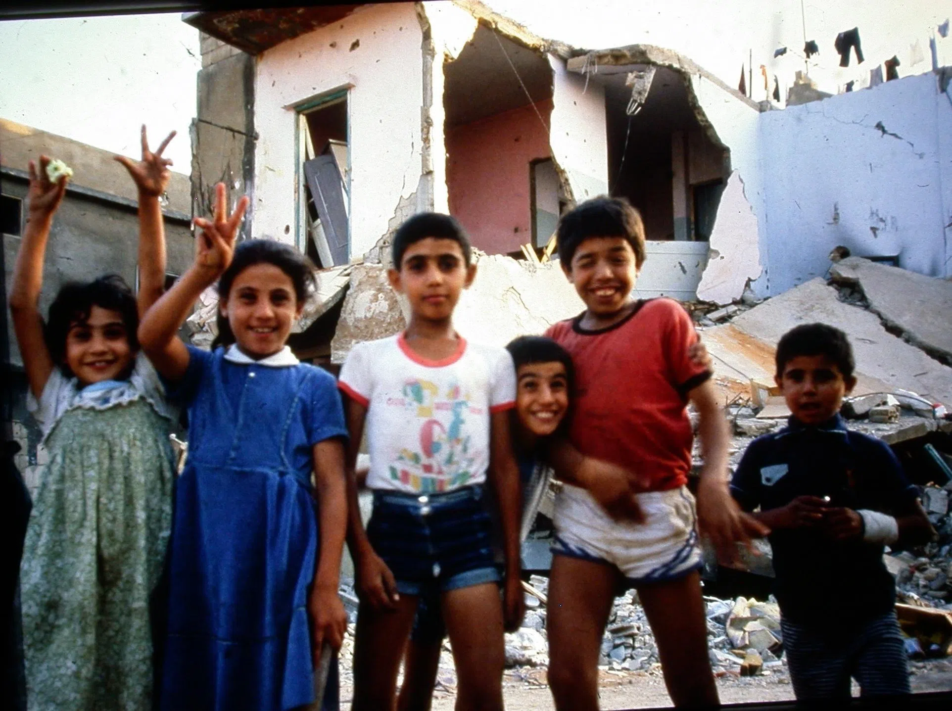 1982年，洪瑞钗沮丧地走在大屠杀后的夏蒂拉难民营附近，突然冒出一个巴勒斯坦小孩。小孩是洪瑞钗曾经救治的病人，央求着她帮大伙拍照，还说“我们不害怕，以色列来吧！”（受访者提供）