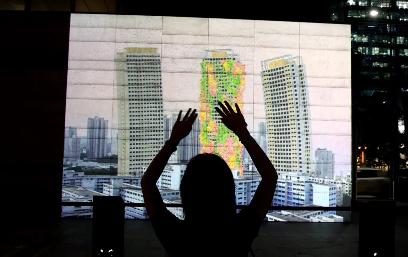 公众可通过摆动肢体为组屋外墙点缀花朵及绿意。 （严宣融）