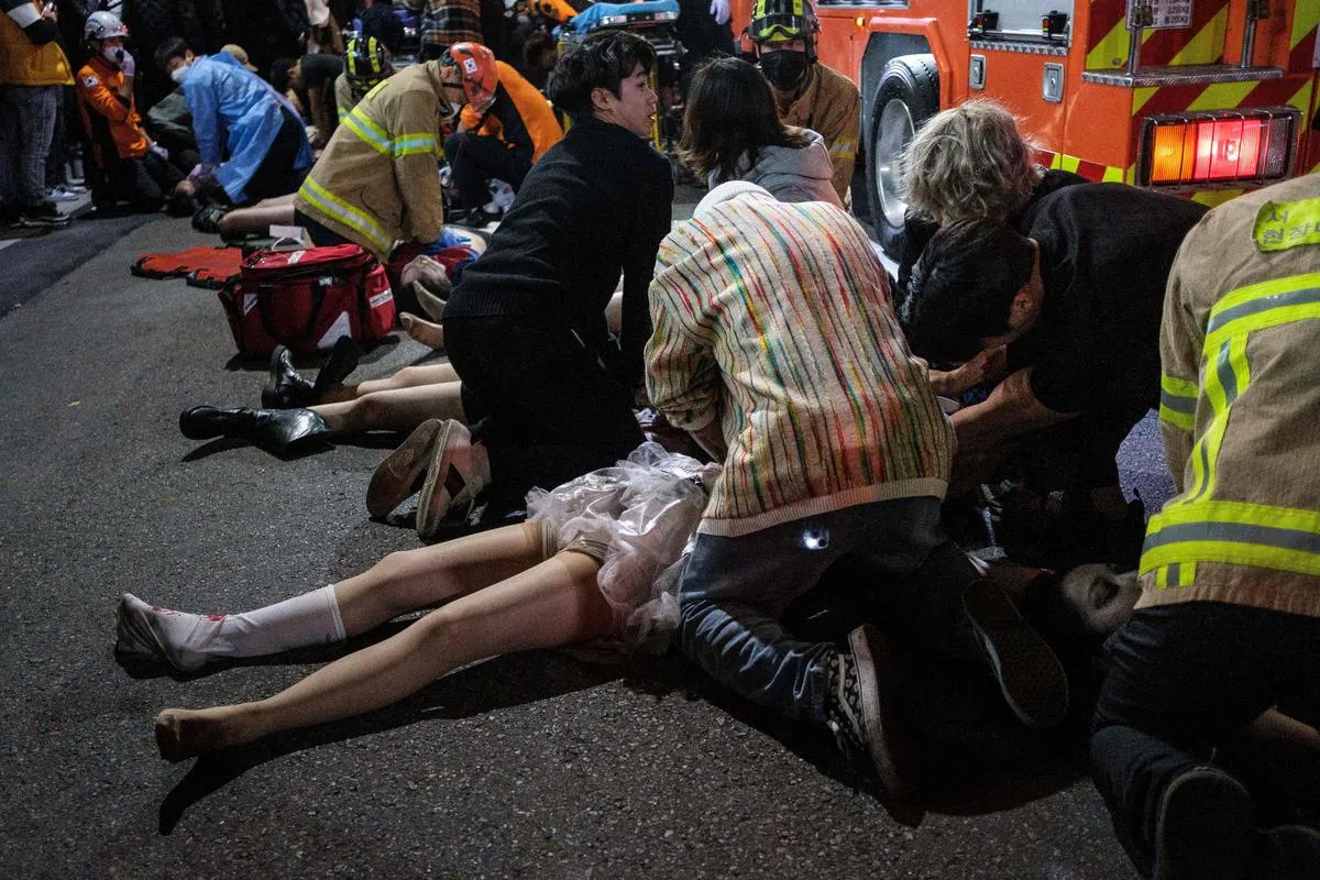 首尔梨泰院踩踏事故过程中，由于过度挤压造成窒息，导致50余人创伤性心脏骤停，现场所见，路人纷纷为伤者进行心脏复苏术抢救。（法新社）