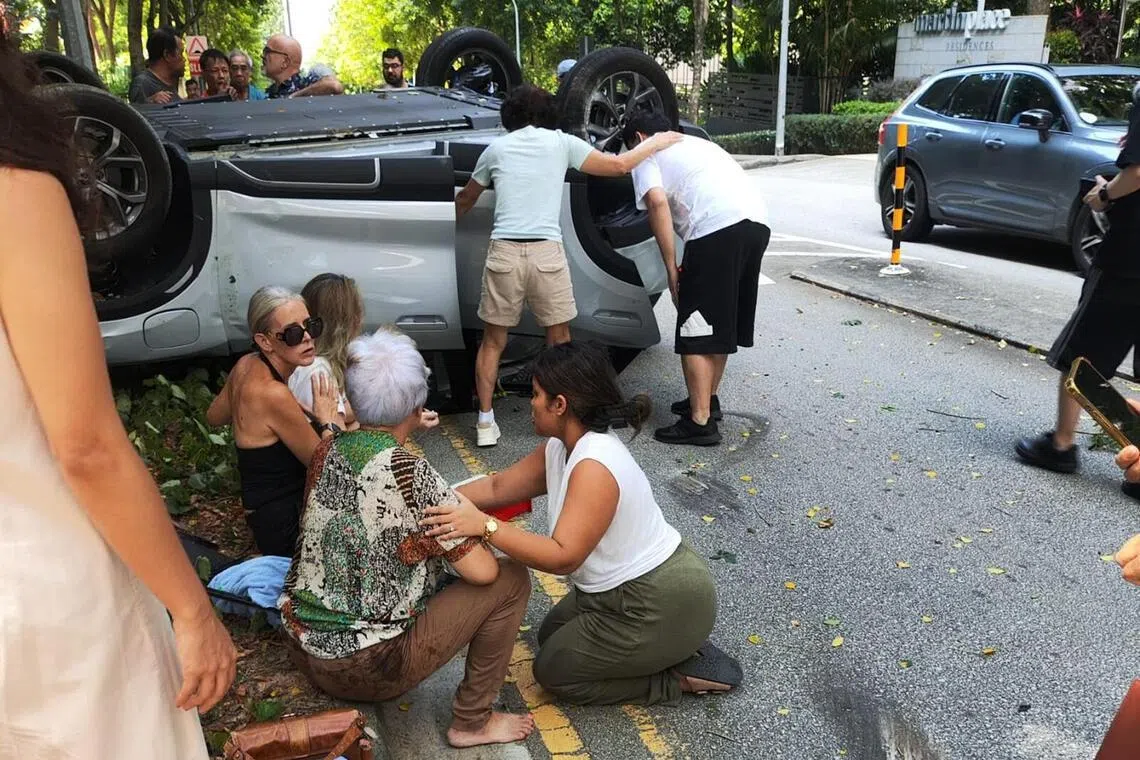 女驾驶与乘客在路人的安慰下坐在路边等候救援。（受访者提供）