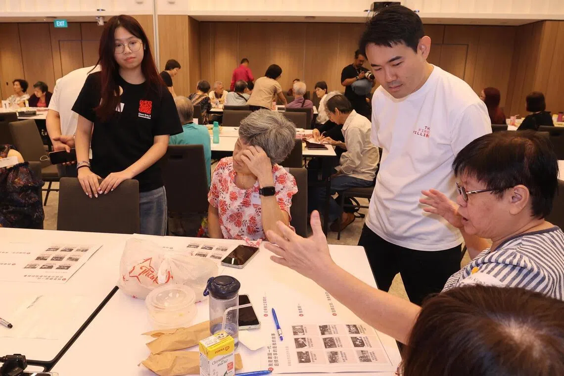 退休教师林爱娇（右，坐）在活动中分享了儿时住在芽笼店屋楼上的见闻，包括目睹私会党收取保护费、亲历种族冲突及趁火打劫等乱象。（邬福梁摄）