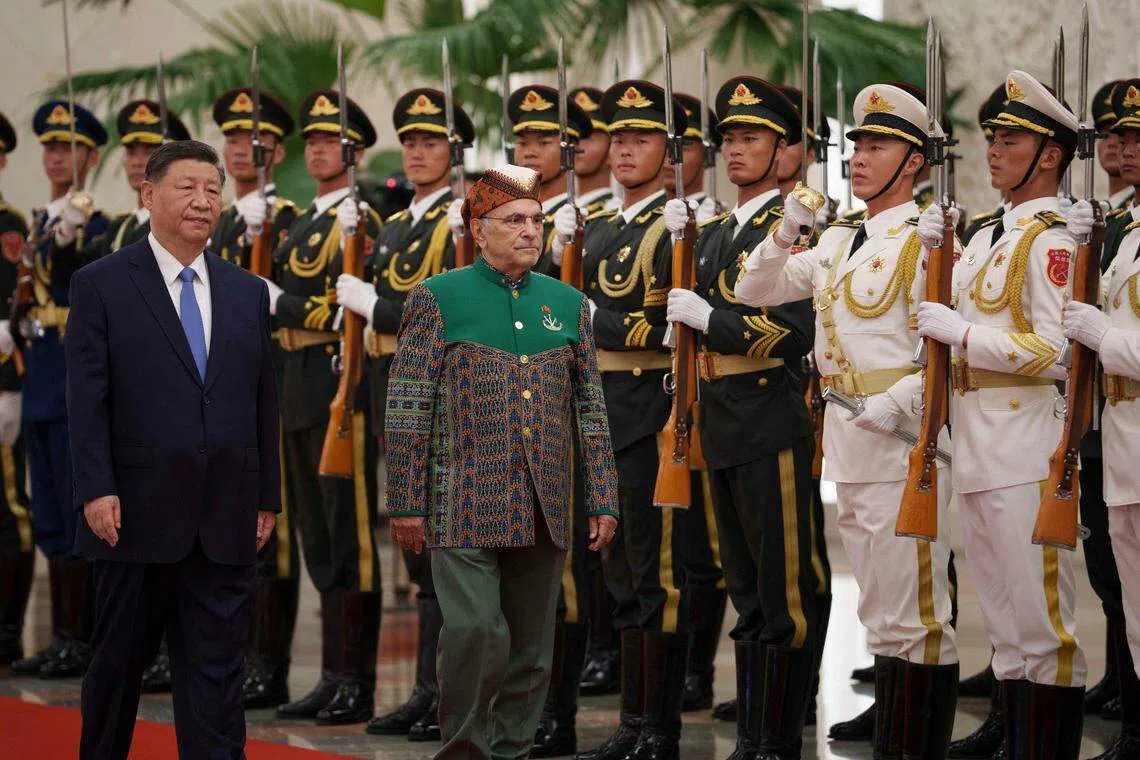 中国国家主席习近平（左）星期一（7月29日）陪同到访的东帝汶总统奥尔塔（中）在北京人民大会堂北大厅的欢迎仪式上，检阅仪仗队。（法新社）