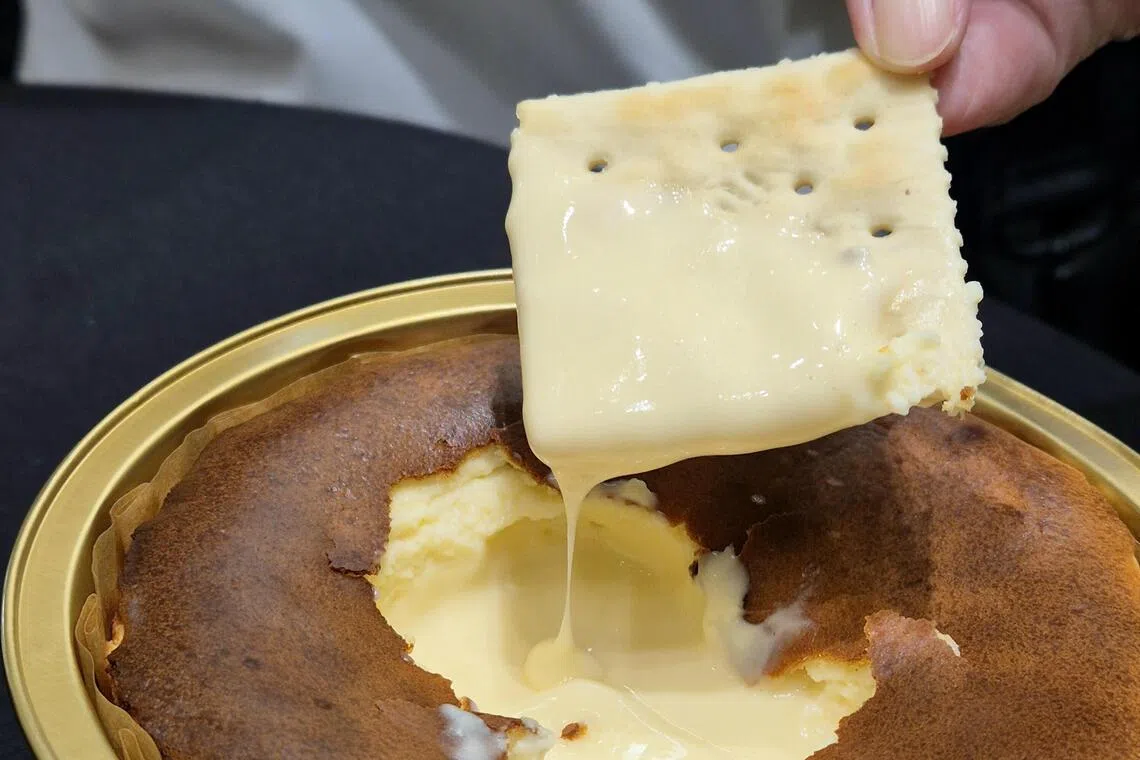 用饼干蘸取芝士蛋糕的流心内馅。（陈爱薇摄）