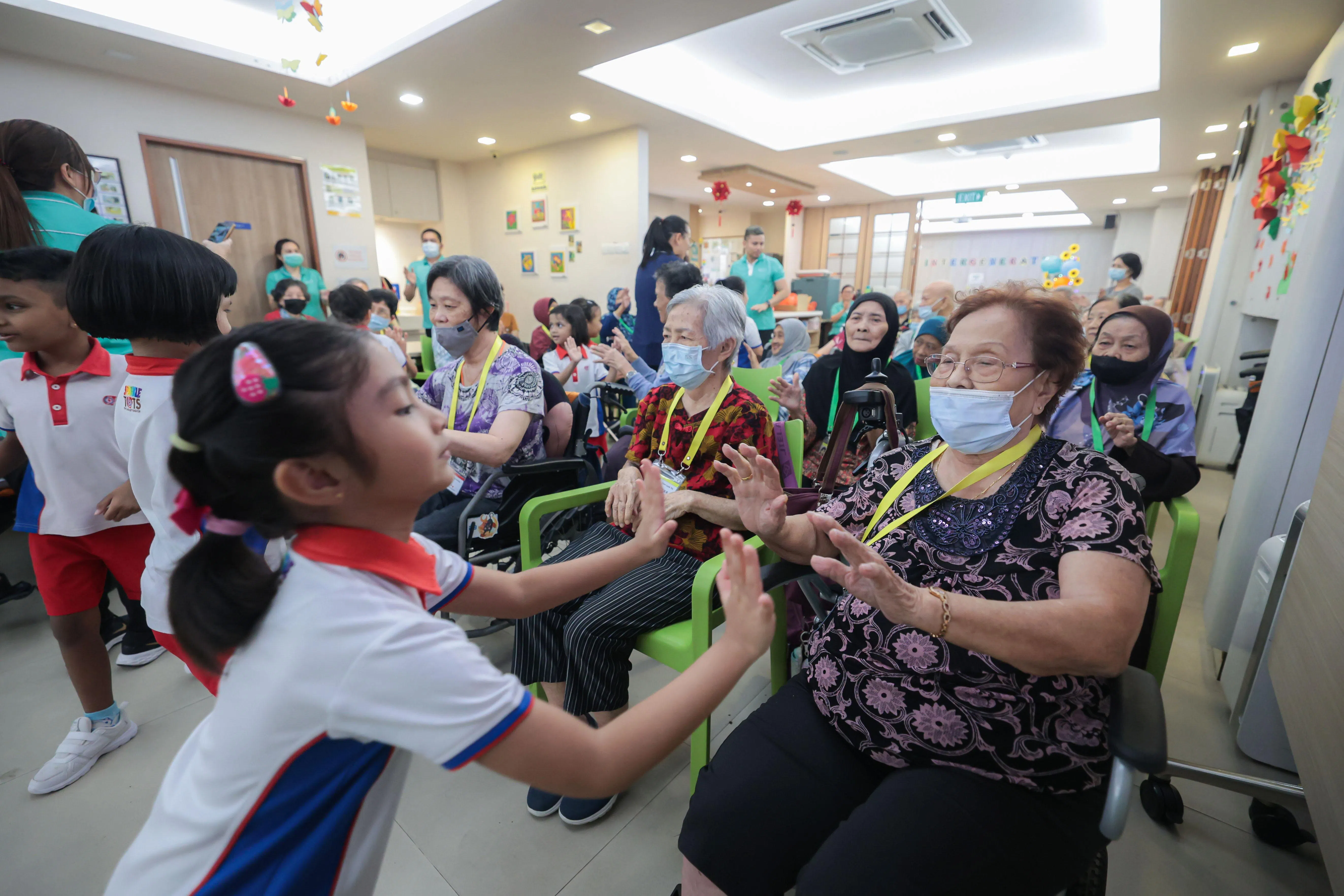 86岁的曾秀琼（右一）每周会到人民行动党社区基金会的Sparkle Care乐龄护理中心三次，她非常珍惜与孩子们的互动时光。（李冠卫摄）