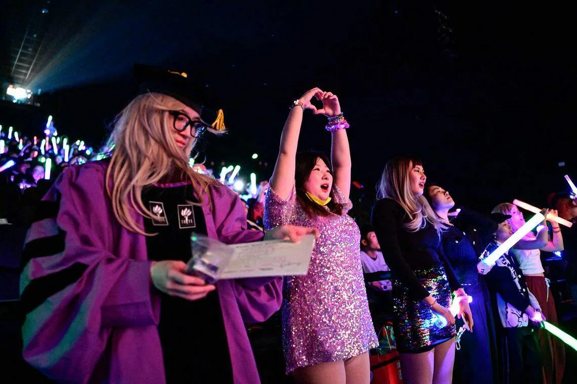 有粉丝已是第八次看这部电影，他们对每首歌烂熟于心，可以跟着音乐一字不落地高唱。图为2月3日一位中国歌迷在观看演唱会电影《泰勒丝：时代巡回演唱会》时比出爱心手势。（法新社）