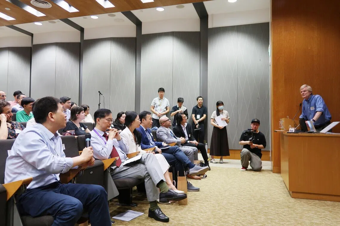 在杜克-国大医学院3月30日举行的神经科学与疾病研究国际研讨会上，中国清华大学生命科学学院院长时松海博士（左一手持话筒者），向美国哈佛医学院儿科与神经学系教授沃尔什（右一站立者）提问，他们也各自在会上分享了和自闭症相关的研究项目（张俊摄）