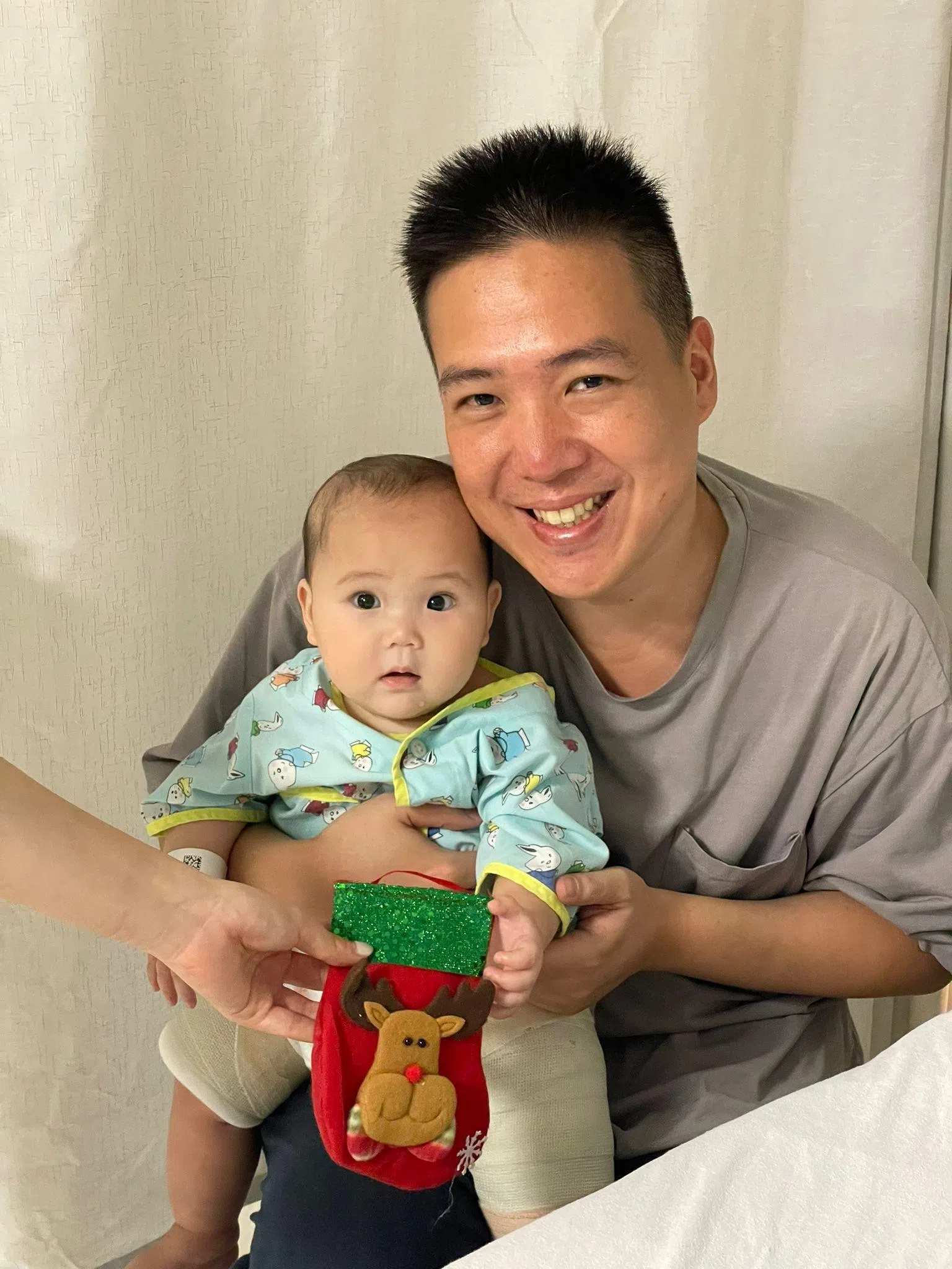 父亲林善智（右）和因股骨骨折正在康复的林智涵（左）一同参与国大儿童医疗中心的圣诞庆祝活动。（受访者提供）