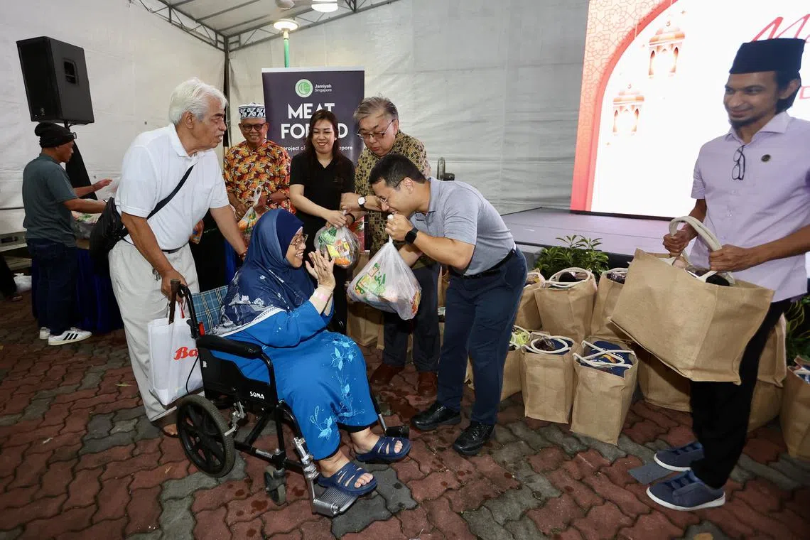 也是西海岸集选区议员的李智陞（右二）在开斋餐后，分发食品礼包给受惠居民。（陈斌勤摄）