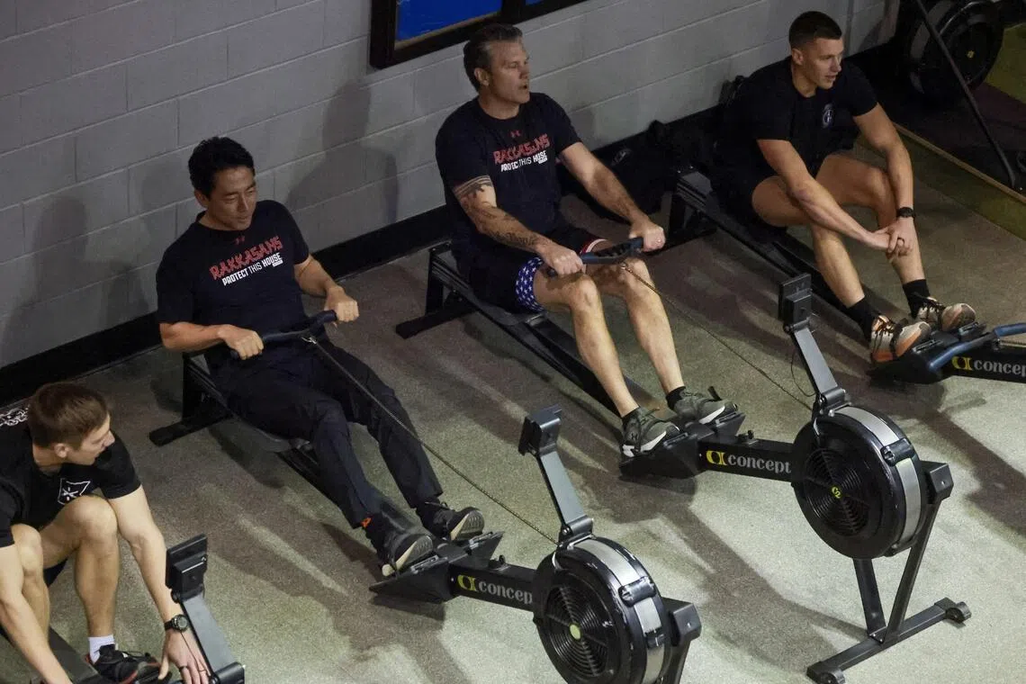 小泉进次郎（左二）和赫格塞斯（左三）周四在美国弗吉尼亚州阿灵顿的迈尔-亨德森联合基地与美国陆军第3步兵团的士兵一起做晨练。（路透社）