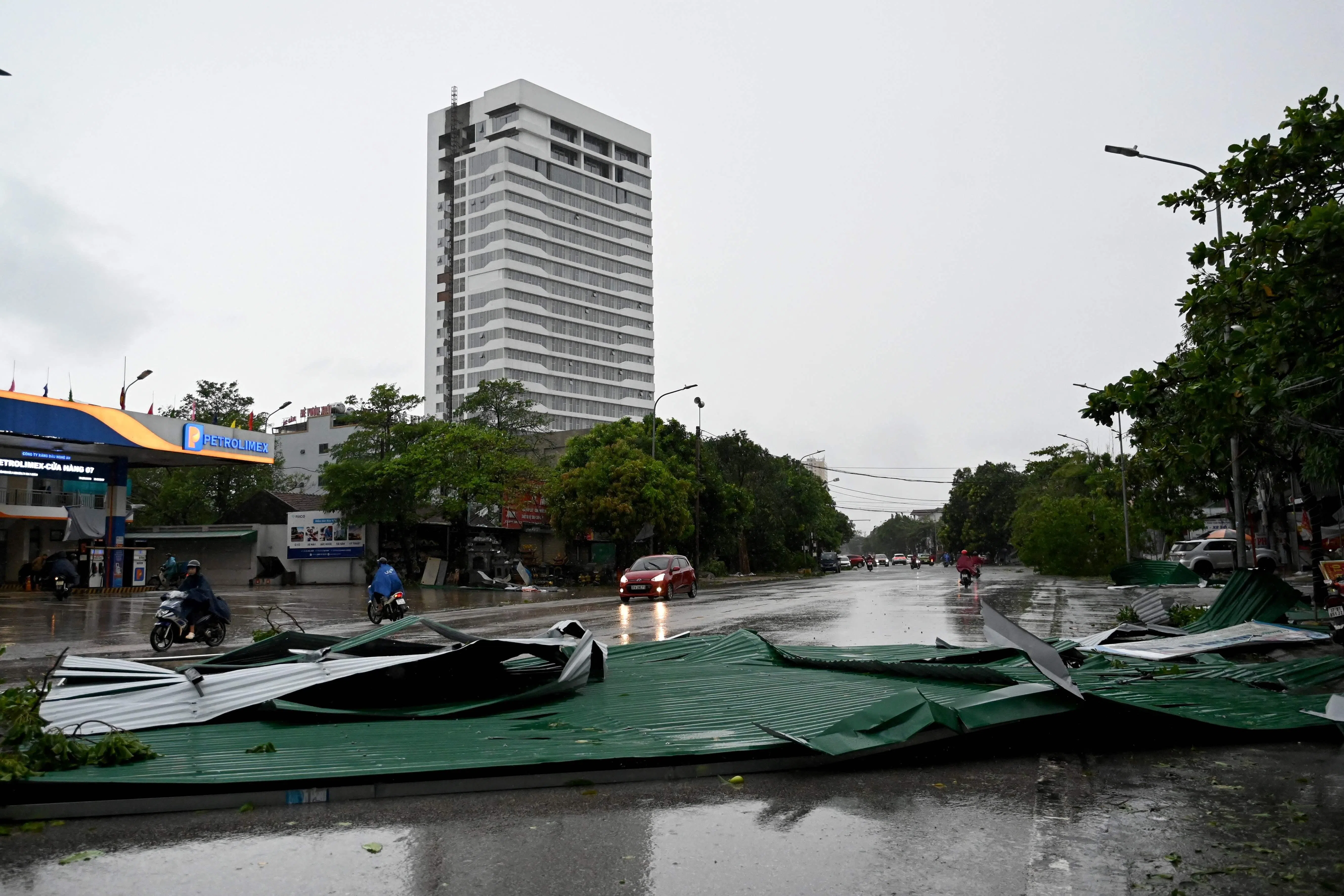 8月26日，台风“剑鱼”吹袭越南义安省后，一个铁皮屋顶掉落在道路中央。（法新社）