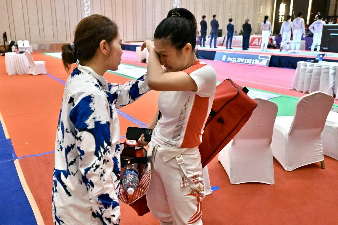 新加坡击剑手王淑慧（右）在佩剑女团半决赛失利，泰国好友送上安慰。（海峡时报）