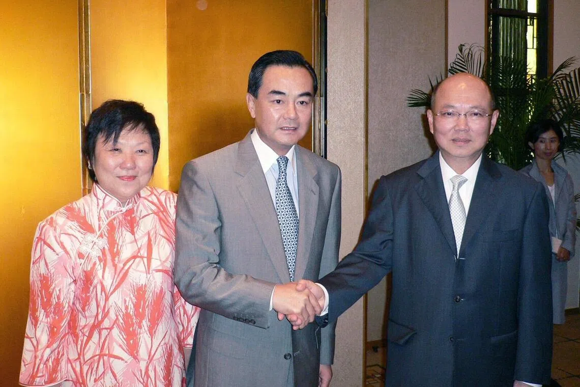 Tan (right) and his wife with China’s former ambassador to Japan Wang Yi (centre) at Singapore’s National Day reception on 8 September 2005.（Courtesy of interviewee）