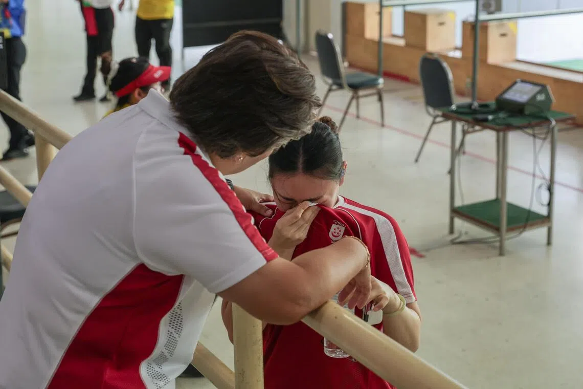 教练李到禧（左）预赛后安慰郑琇憶（中），后者在精准射击阶段发挥亮眼排名全场第二，但在速射环节状态不佳。（白艳琳摄）