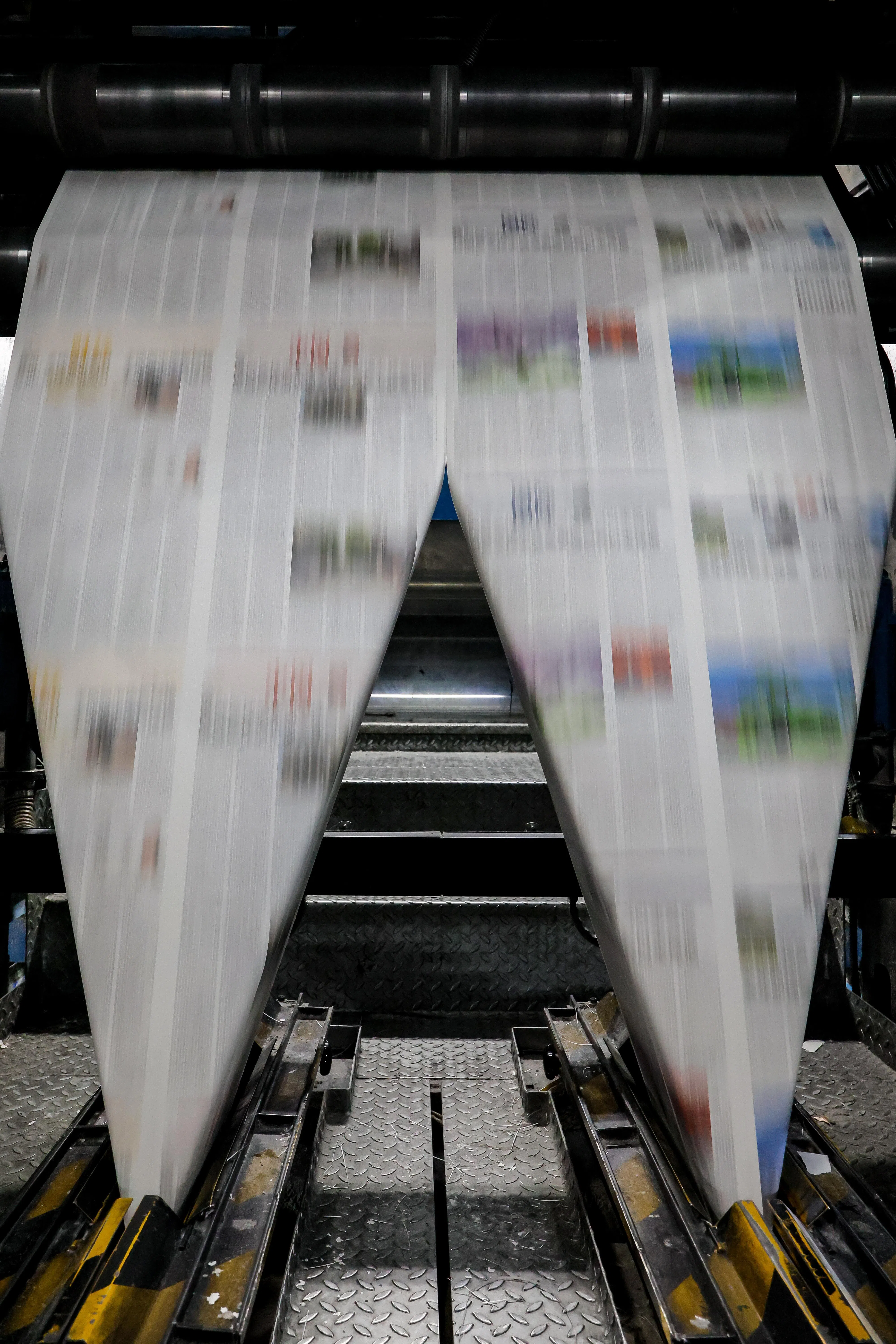 如同绅士戴上领结，折报机将印出的大幅报页对折叠加，一份报纸就此成形。（龙国雄摄）