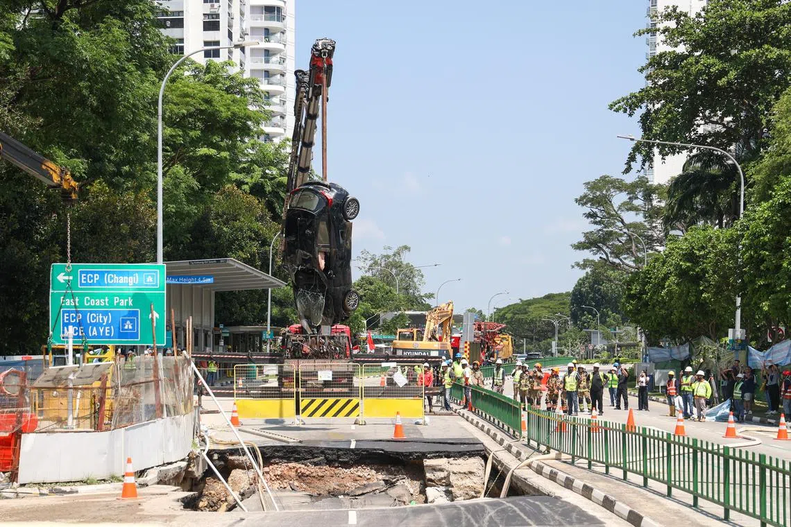 掉入地陷坑中的车子在星期天下午2时吊起。（吴先邦摄）