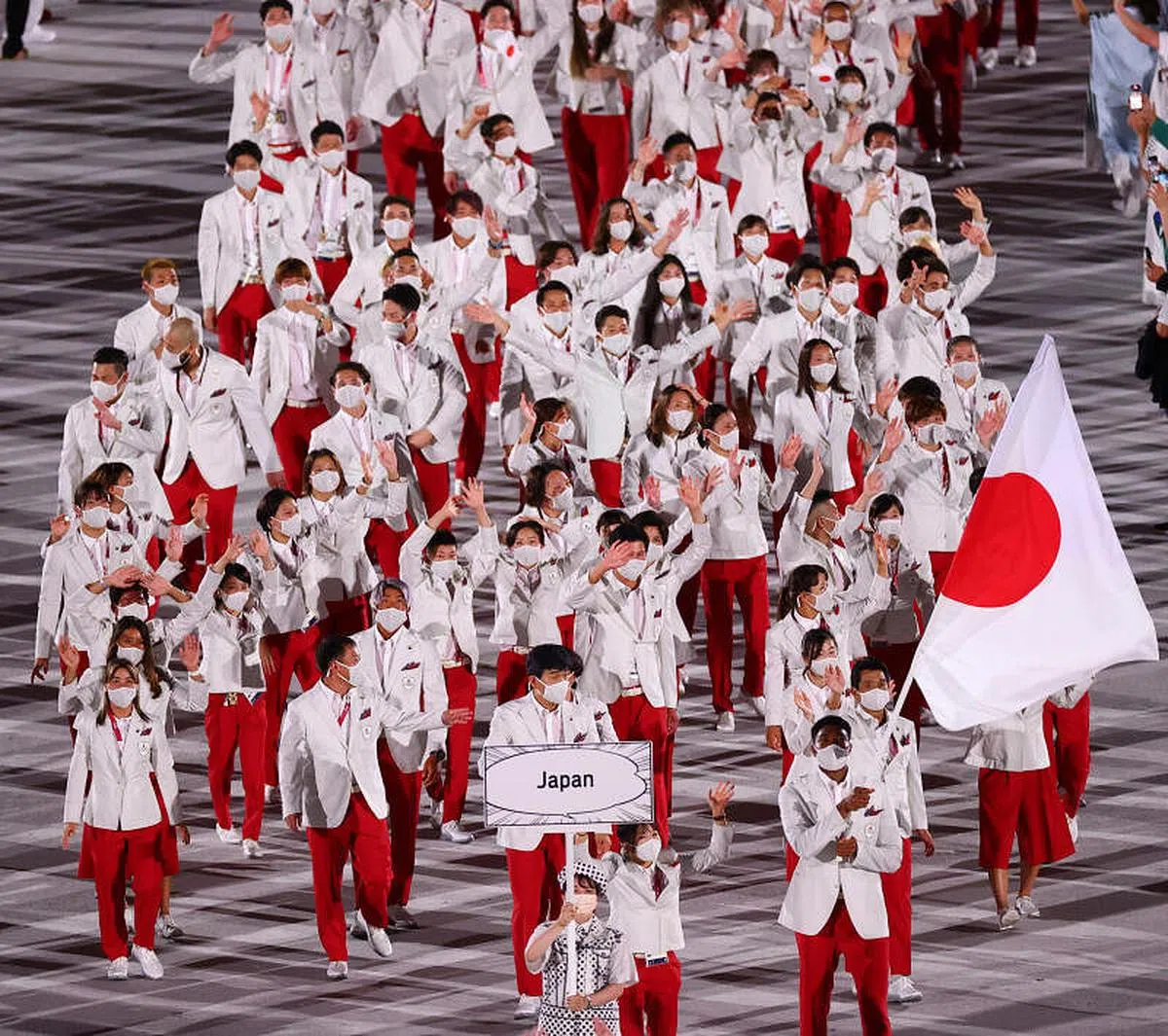 东道主日本的奥运代表团在摔跤运动员须崎结衣（Yui Susaki，左）和篮球运动员八村锐（Rui Hachimura，右）的带领下入场。 
