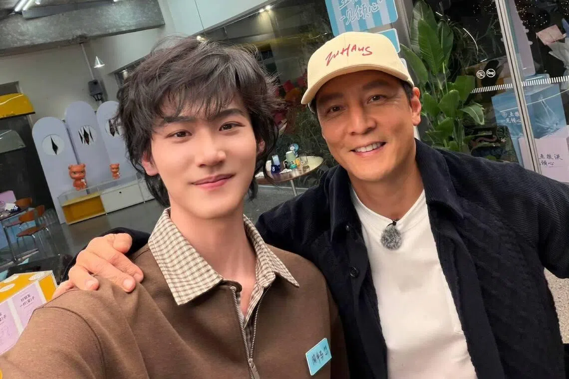 周柯宇（左）“带薪追星”与偶像吴彦祖合照。（取自官方微博）