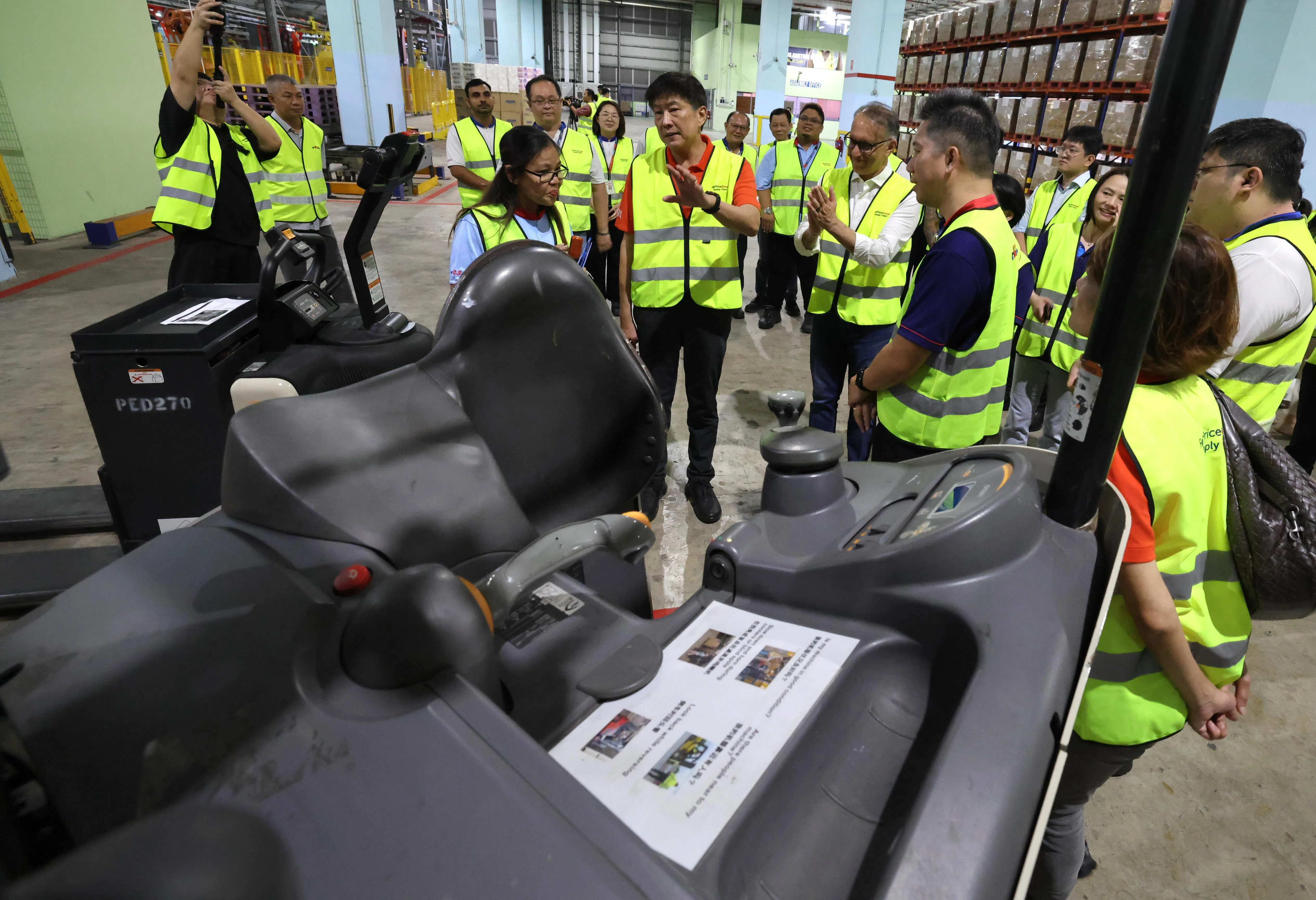 职总秘书长黄志明（中间说话者），10月29日到平价集团位于裕群的贲耐配送中心，向员工了解工作流程。（梁麒麟摄）