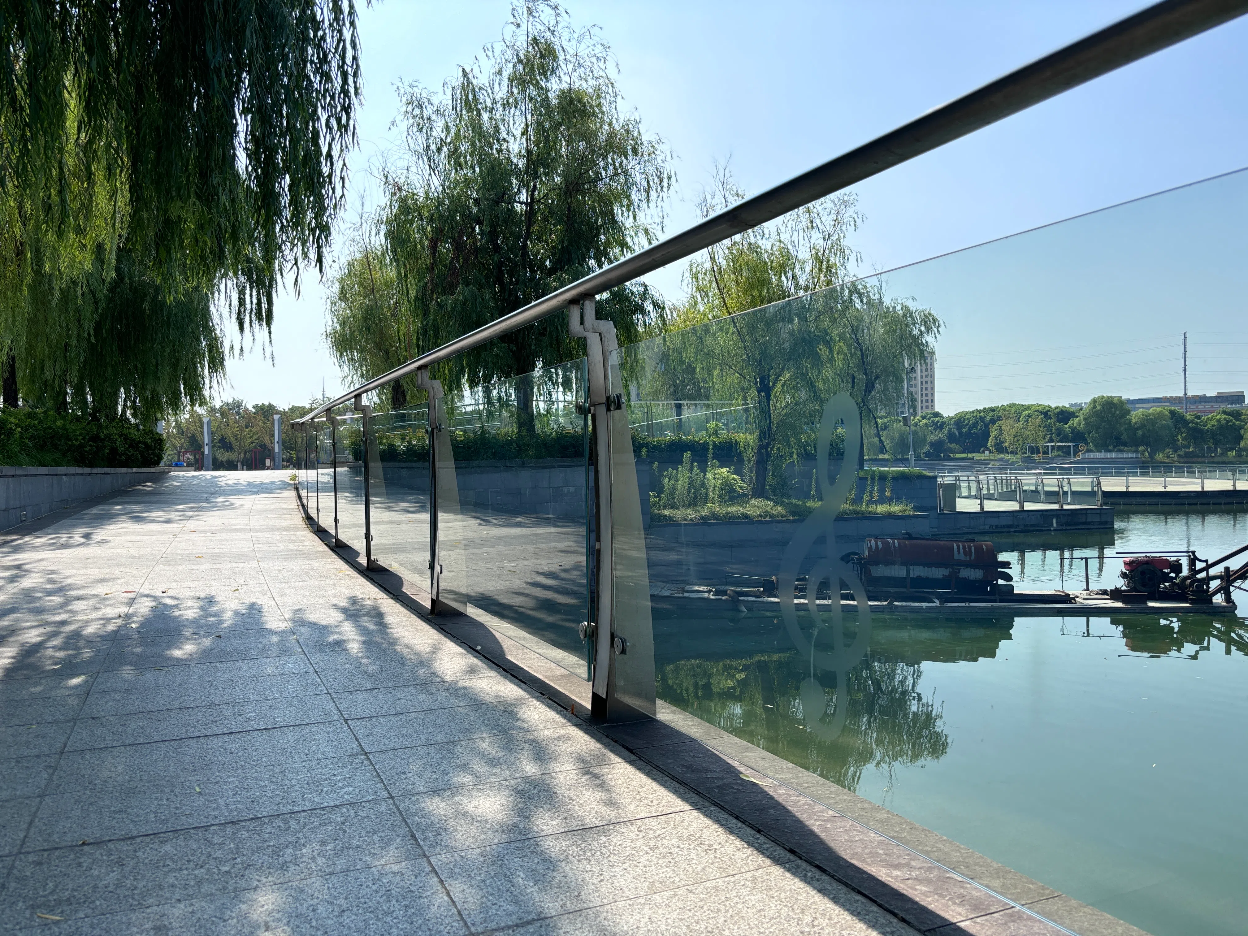 黄桥镇人工湖的玻璃围栏上，隐约透出高音符号的标记。（黎康摄）